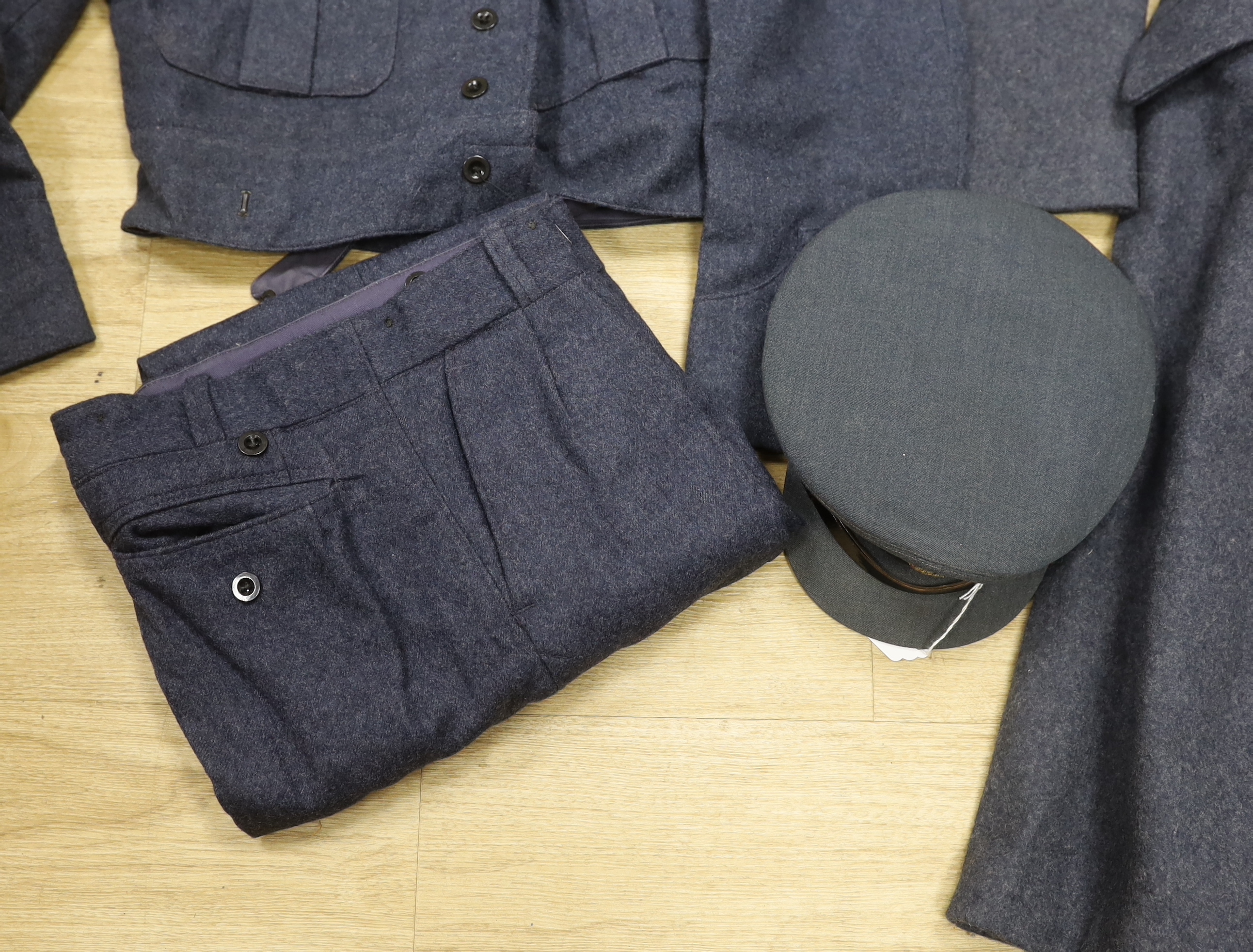 A 1960s RAF uniform comprising; great coat, blouse, cap and trousers, all with manufacturer’s labels, broad arrow markings, dates, etc.